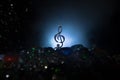 Musical symbol treble clef stainless steel miniature with colorful toned light on foggy background. Selective focus Royalty Free Stock Photo