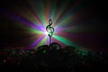 Musical symbol treble clef stainless steel miniature with colorful toned light on foggy background. Selective focus Royalty Free Stock Photo
