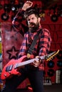 Musician with beard play electric guitar. Man with enthusiastic face Royalty Free Stock Photo