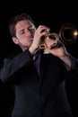 Musician in black suit playing a trumpet