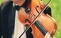 Musician with bow tie plays violin outdoors Royalty Free Stock Photo