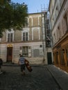 Musician carries acoustic bass up cobbled street on Montmartre in Paris, France