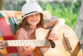 Musician child playing guitar. Kid girl singing and playing guitar outside. Kids music and songs. Smiling child playing Royalty Free Stock Photo