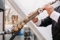 A musician at the event in a frock coat and bow tie plays the saxophone. ÃÂ¡lose-up of hands and tools.