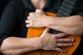 Musician hands embracing a classic acoustic guitar