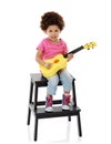 Musician in the making. Studio shot of a cute little girl playing with her toy guitar against a white background. Royalty Free Stock Photo