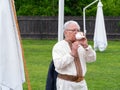 Musician man plying conch, conchor, conque, seashell horn or shell trumpet from sea snail ethnic wind musical instrument