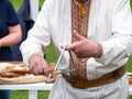 Musician man plying triangle striking beater. Ukraininan idiophone metal ethnic musical instrument. Folk music festival