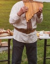 Musician man in vyshyvanka plying sopilka rebro ethnic woodwind musical instrument. Pan flute music festival in Ukraine Royalty Free Stock Photo