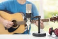 Musician with microphone playing acoustic guitar and recording music on computer Royalty Free Stock Photo