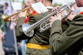 Musician of military orchestra playing trumpet during parade