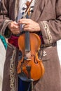 Musician in an old costume holds a violin in his hands_ Royalty Free Stock Photo