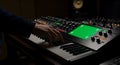 Musician orchestrating electronic composition with keyboard and greenscreen device Royalty Free Stock Photo