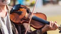 Musician performs a tune on the violin on the street_