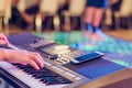 Musician play electronic keyboard synthesizers by using smartphone as guidelines for playing on the concert stage. Selective focus