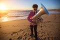 Musician play to musical instrument Tuba on ocean shore. Hobby. Royalty Free Stock Photo