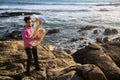 Musician play to musical instrument Tuba on romantic rocky sea shore. Hobby.