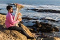 Musician play Tuba on sea beach. Concert.