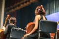 Musician play violin. Female violinist playing the violin stringst on the concert stage. Closeup.