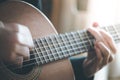 Musician is playing a classical guitar, fretboard and fingers