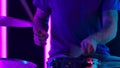 Musician playing drums in the background pink neon tubes. Close up of a man's hand playing on snare and hihat with