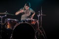 Musician playing drums with splashes, black background with beautiful soft light