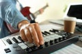 Musician playing on electric guitar and midi keyboard, close up