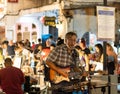 Musician playing the guitar at Thai street food market, Old Town, Phuket, Thailand