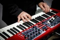 Musician playing on red electric keyboards. Royalty Free Stock Photo