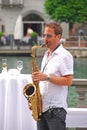 A jazz musician playing saxophone at the street next to Reuss river at Lucerne