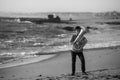 A musician playing a tuba on the Atlantic beach. Black and white photo. Royalty Free Stock Photo