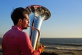 Musician playing the Tuba on the ocean coast. Hobby. Royalty Free Stock Photo