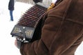 The musician plays accordion in winter weather on the feast. Royalty Free Stock Photo