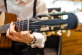 The musician plays the acoustic guitar on stage. Guitar neck close-up in the hands of a musician.