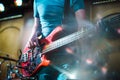 The musician plays the electric bass guitar on stage. Guitar neck close-up on a concert of rock music in the hands of a musician. Royalty Free Stock Photo