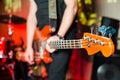 The musician plays the electric bass guitar on stage. Guitar neck close-up on a concert of rock music in the hands of a musician Royalty Free Stock Photo