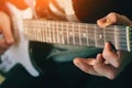 The musician plays an electric guitar and holds the chords with his fingers