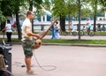 A musician plays an ethnic African instrument in a summer park