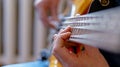 The musician plays a five-string bass guitar at home