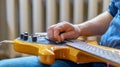 The musician plays a five-string bass guitar at home