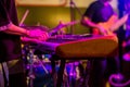 Musician`s hands playing keyboard at a live show on stage with other men playing guitars