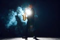 Musician with saxophone performing piece on stage with smoke. Backlit creating silhouette effect. Instrumental music. Royalty Free Stock Photo