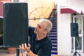 Musician setting up the speaker on a stage on a terrace