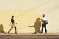 Musician on Sidewalk and Woman Pedestrian