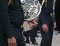 Musician soldier standing holding a French horn for playing in a marching band.