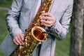 Musician suit performs melody saxophone outside summer