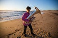 Musician with a tuba playing on the sea beach. Hobby.