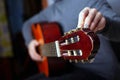 The musician tunes an acoustic six-string guitar