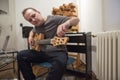 Musician tuning electric guitar in home music studio