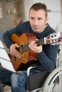 musician in wheelchair playing guitar at home Royalty Free Stock Photo